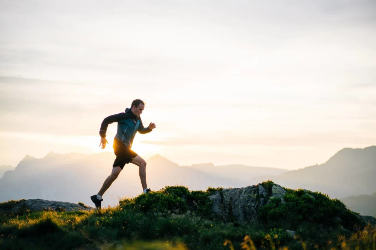 Man runs on mountain ridge at sunrise